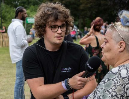 Jesse Sprikkelman interviewt een festivalganger voor de radio.