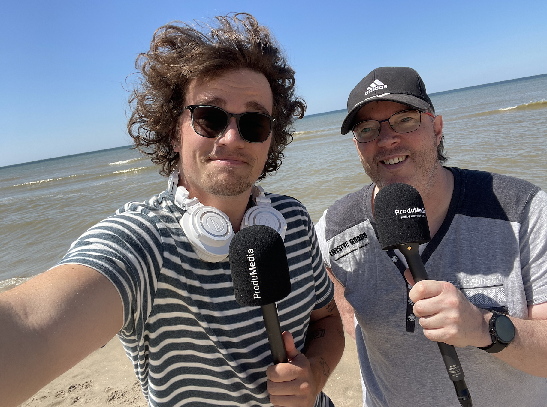 Jesse Sprikkelman en Ron Selles maken radio vanaf het strand in Noordwijk.
